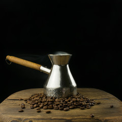 Old vintage coffee maker. Grains of coffee on a wooden table.