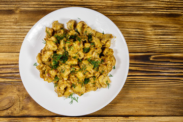 Stewed mushrooms with sour cream on wooden table. Top view