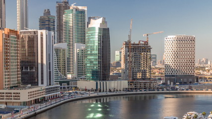 Obraz na płótnie Canvas Skyscrapers near canal in Dubai with blue sky aerial timelapse