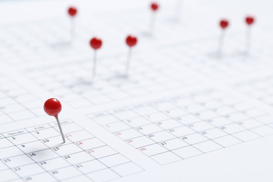 Close up of red pin on calendar at home office, date planning for business meeting or appointment, deadline or holiday concept © PANDA