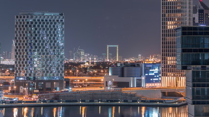 Obraz na płótnie Canvas Bright night in Dubai near canal aerial timelapse