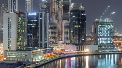 Bright skyscrapers in Dubai near canal aerial timelapse
