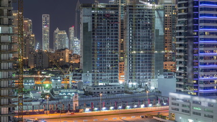 Aerial view of constructing with cranes night timelapse in Dubai.