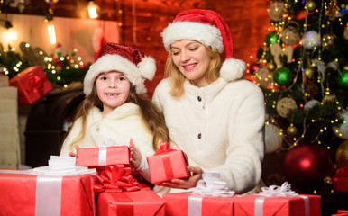 Obraz na płótnie Canvas Winter holiday. Gifts for girls. Mom and child with gift boxes. Surprise for daughter. Happy holidays. New year tradition. Boxing day. Wrapped gifts near christmas tree. Preparing gifts for family
