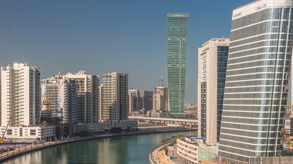 Fototapeta na wymiar Skyscrapers near canal in Dubai with blue sky aerial timelapse
