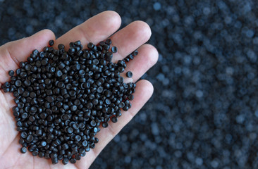 Close-up of plastic polymer granules. hand hold Polymer pellets. polymer plastic. compound polymer.