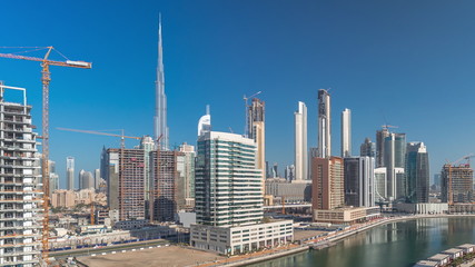 Obraz premium Skyscrapers near canal in Dubai with blue sky aerial timelapse