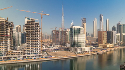 Fototapeta na wymiar Skyscrapers near canal in Dubai with blue sky aerial timelapse