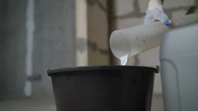 The primer is diluted with water using a flask. Priming the floor. Preparation of building primers for priming the floor. The primer is diluted with water.
