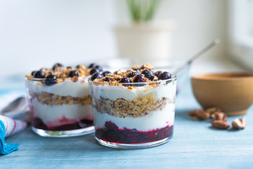 Traditional homemade French dessert of berries, grated nuts, jam and yogurt - parfait in glasses