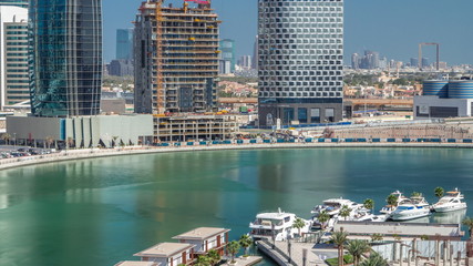 Fototapeta premium Skyscrapers near canal in Dubai with blue sky aerial timelapse