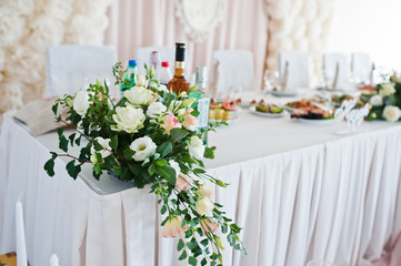 Beautiful wedding set decoration in the restaurant. Flowers on table of newlywed.