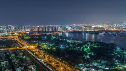 Fototapeta premium Nighttime rhythm of the city of Dubai near canal aerial timelapse
