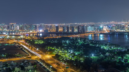 Nighttime rhythm of the city of Dubai near canal aerial timelapse