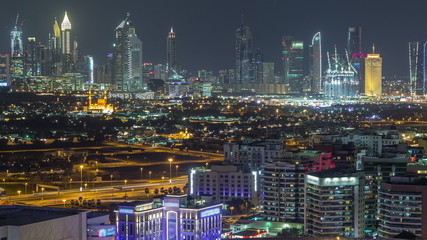 Naklejka premium Modern view of illuminated buildings appartments and skyscrapers in Dubai Timelapse Aerial
