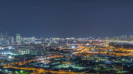 Fototapeta na wymiar The rhythm of the city at night with illuminated road in Dubai near canal aerial timelapse