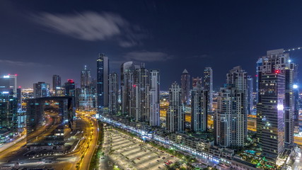 Fototapeta na wymiar Modern residential and office complex with many towers aerial night timelapse at Business Bay, Dubai, UAE.