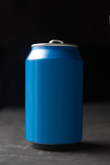 Isolated aluminium can mockup on a black wooden table against a dark background. Empty copy space for Editor's text.