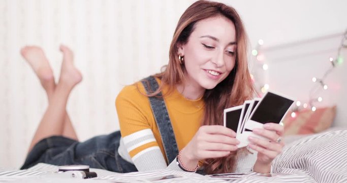 Female in bedroom looking at old pictures with memories