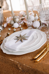 New Year 2019. New Year mood. Table with a gold tablecloth, decorated with candles and tableware for celebration. Festive still life by candlelight. Close-up.