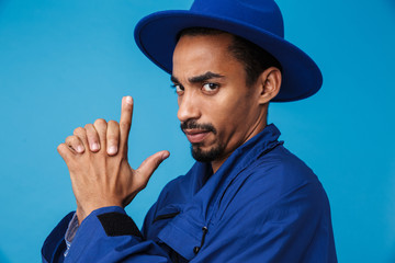 Photo of serious african american man making gun gesture