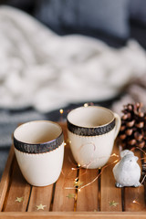 Table with a cup on the bed, marshmallow and Christmas cookies, cozy knitted blanket. New Year 2019, flat lay. Christmas composition with a cup tray and a mug