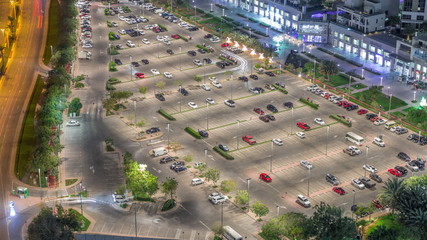 Nighttime view of a lot of cars in illuminated parking in Dubai timelapse aerial