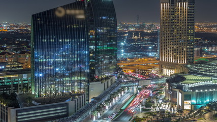 Obraz premium Dubai downtown street with busy traffic and skyscrapers around night timelapse.