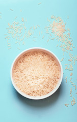 Rice in the bowl in front of the blue background