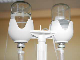 Dropper with saline. System with dropper and solution, closeup. Postoperative dropper