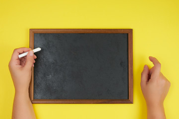 black chalk frame and two female hands with a piece of white chalk