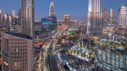 Fototapeta na wymiar Panoramic skyline view of Dubai downtown after sunset with mall, fountains and skyscrapers aerial day to night timelapse