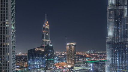 Panoramic skyline view of Dubai downtown with mall, fountains and skyscrapers aerial night timelapse