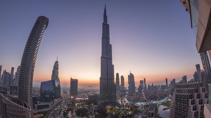 Fototapeta na wymiar Panoramic skyline view of Dubai downtown before sunrise with mall, fountains and skyscrapers aerial night to day timelapse