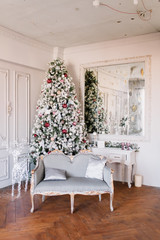 New Year 2020. Christmas beautiful lights on gold warm background. Christmas tree, toys. Photo of the interior of a room with a blue wall, garlands, fireplace with candles.