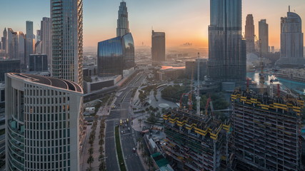 Panoramic skyline view of Dubai downtown before sunrise with mall, fountains and skyscrapers aerial night to day timelapse