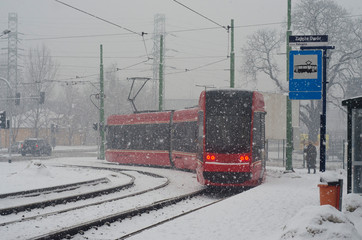 Opady śniegu w Katowicach, tramwaj na przystanku.