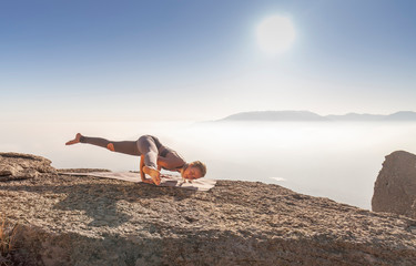 girl practices yoga in the mountains