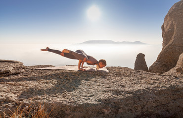 girl practices yoga in the mountains