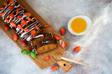 Delicious honey cake for tea decorated with sugar Fudge and fresh red strawberries.  Horizontal...
