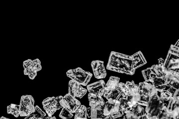 Magnified image of sucrose crystals. White sugar crystals on a black background. Refined product.