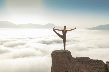girl practices yoga in the mountains