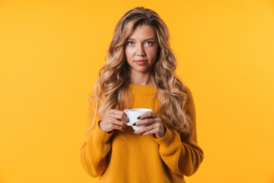 Image of beautiful blonde woman wearing warm sweater holding coffee cup