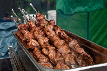 Couple of big meat skewers with meat chunks roasted on barbecue grill - concept food eat lifestyle activity tradition traditional fresh red bloody flesh brazier BBQ roast meal hunger health recipe