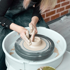 Woman making ceramic pottery on wheel, hands close-up, creation of ceramic ware. Handwork, craft,...