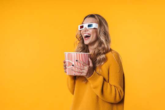 Image of woman in 3D glasses holding popcorn bucket while watching movie