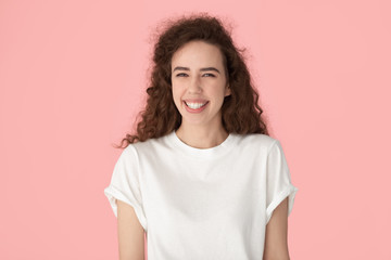 Fototapeta premium Portrait of smiling millennial girl posing on pink background