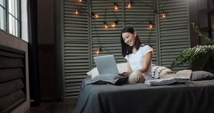 Young panasian girl having a video chat with her friends via internet. Student talking to her parents using laptop. pretty woman chatting with her boyfriend - communication concept 4k