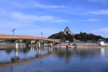 Fototapeta na wymiar 海岸に建った美しい城と赤い橋