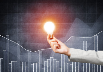 Human hand with glowing incandescent lamp